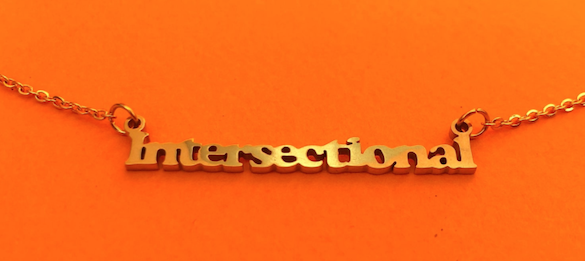 A gold plated metal name plate that reads intersectional 