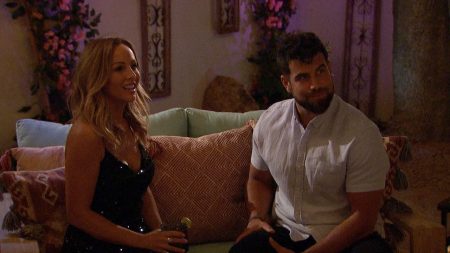 Clare and Blake sit on a couch