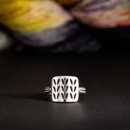 A square silver ring with a stockinette pattern