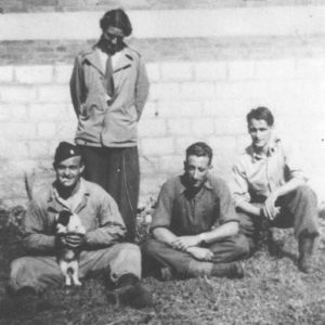Virginia with her "boys." Paul, her future husband, is in the white shirt on the far right. Virginia is standing and the men are seated, one is holding a small dog.