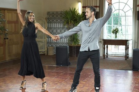 Tayshia and Zac dancing. They are holding hands and have their other arms up in the air