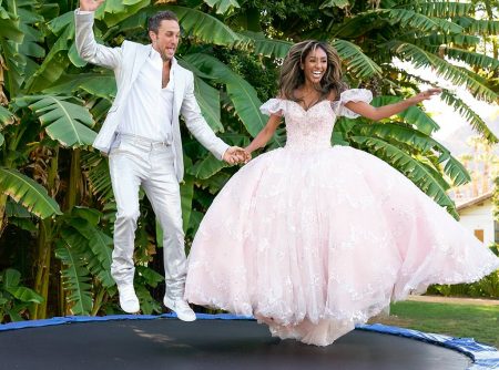 Zac and Tayshia in wedding finery jump on a trampoline