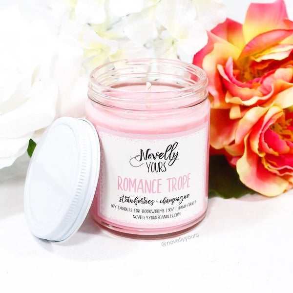 Novelly yours romance trope a pink candle with a white label and lid