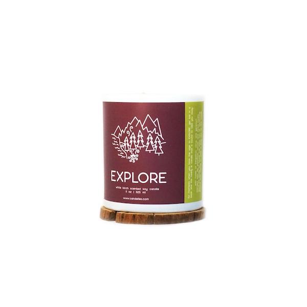 candelles explore candle with a maroon label featuring a line illustration of mountains and a campfire