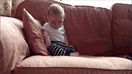 A little kid collapses face down on a couch