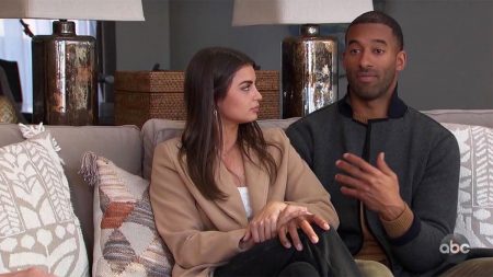 Rachael sits next to Matt on a sofa