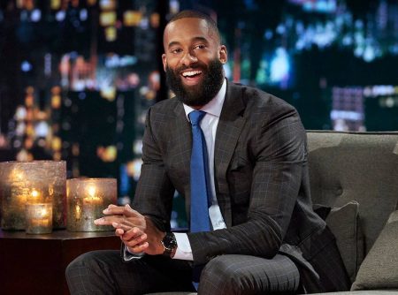 Matt now sporting a beard sits on a couch