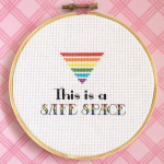 This is Safe Space cross stitch with a queer rainbow triangle above the words
