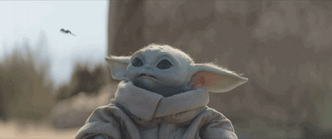 grogu reaches for a small winged creature