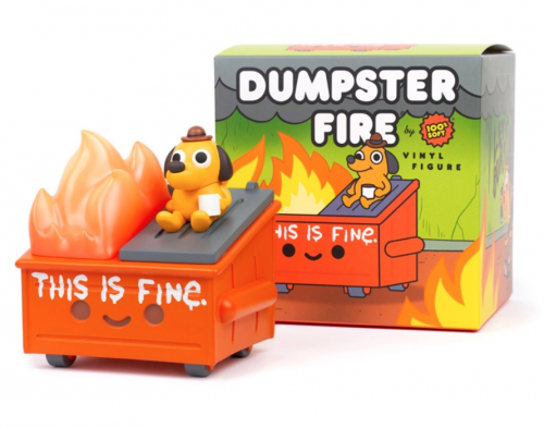 A plastic figure of the dog holding coffee in a flaming room from the THIS IS FINE meme sitting atop a smiling orange dumpster that's on fire with the words THIS IS FINE on the front 
