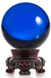 A cobalt blue glass sphere on a tiny wood stand with little lions carved in the wood