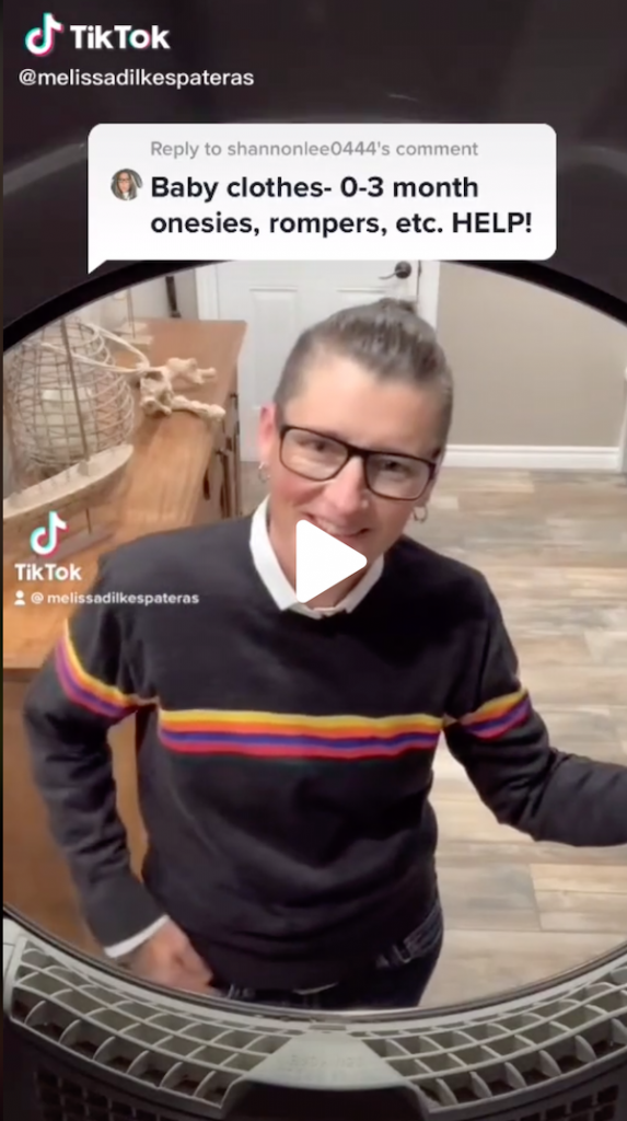 A still from the video showing Melissa opening the dryer and answering a request for how to fold up tiny baby clothes