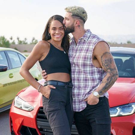 Martin kisses Michelle's forehead as they pose in front of a car