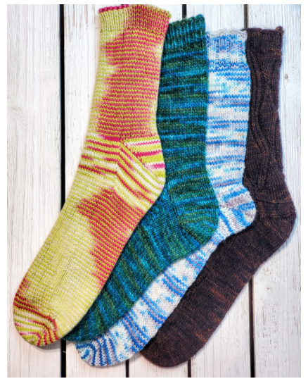 Multicolor knit socks in yellow, green, blue and burgundy red against a wood plank background