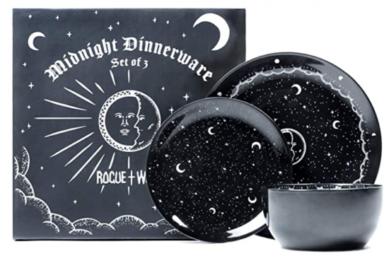 Black shiny plate bowl and small plate with moons and stars against a black background