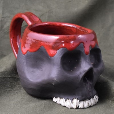 A dark grey skull with blood on the top and the handle hollowed out so you can drink out of it - it's sculpted