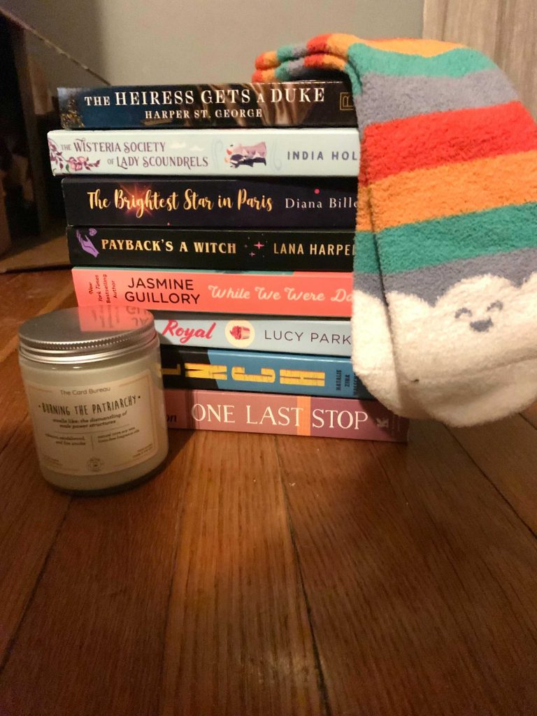 A stack of books with cute socks and a candle