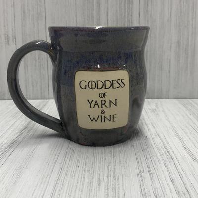 a gray mug that says goddess of yarn and wine