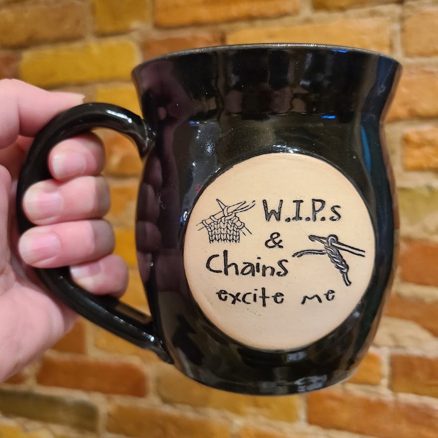 A black mug that says Wips and chains excite me