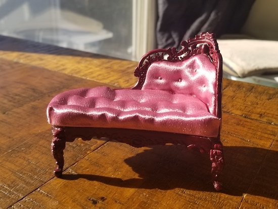 A victorian chaise in hot pink satin with a dark carved wood finish