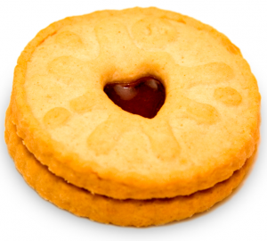 A close up of a Jammy Dodger, a shortbread cookie with jam filling and a heart cut out 
