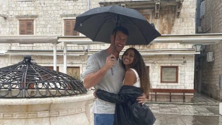 Clayton and Teddi cuddle under an umbrella