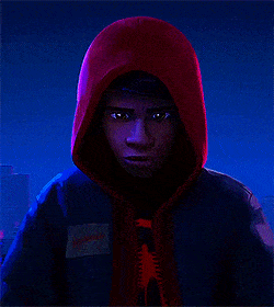 Miles Morales, wearing a red hoodie, pulls on his Spider-Man mask