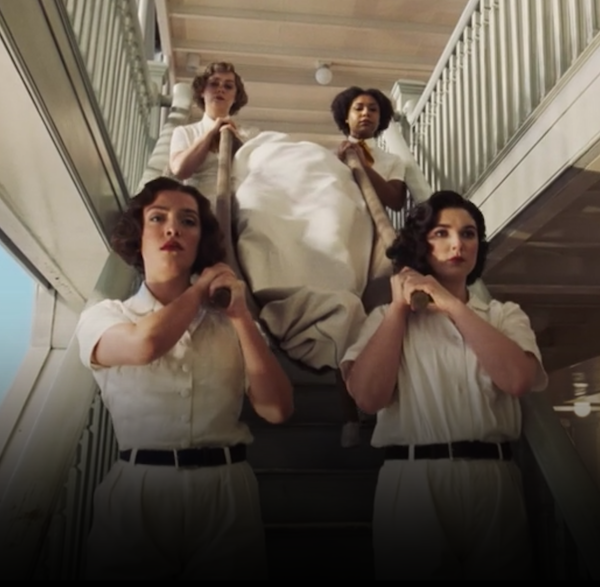 Four women of the ships crew in nearly identical hair styles and matching red lipstick cart a wrapped body down some steep stairs except the body is in a sort of canvas sling and there is nothing preventing it from sliding out the front past the very stylish pallbearers
