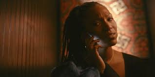 Mollie listens to her phone with a perplexed and somewhat pained expression on her face