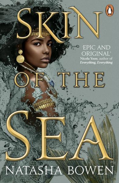 Skin of the Sea by Natasha Bowen. A young Black woman with an afro-style hair. She's a mermaid, with a pale green tail. She's covered in gold jewelry. The title is in bright gold.