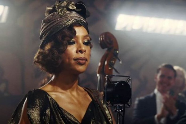Sophie Okonedo singing in an early scene of the film in a purple turban and purple gown with a deep v neck