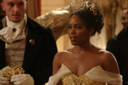 Nicole looks stunning in her ballgown it's strapless with points in the front with gold overlap and white tulle or chiffon draped from the bodice over the tops of her arms. She's also wearing a celestial crown on her head in gold with moons and stars