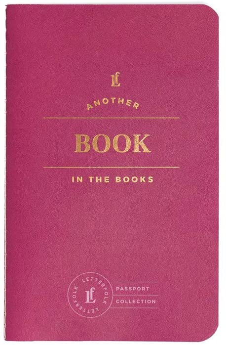 A small magenta paperback journal with gold lettering on the front.