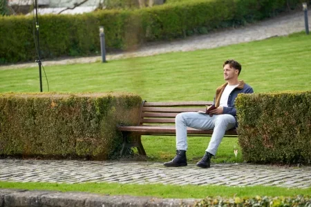 Logan sits alone on a bench