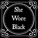 She Wore Black Podcast logo with white gothic lettering against a black background with whilte dots and filigree in a circle around the words