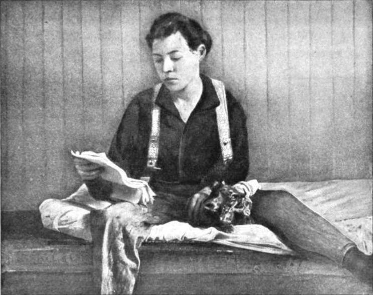 Black and White photo of Lillie in men's clothing seated on bunk in jail cell with a cat