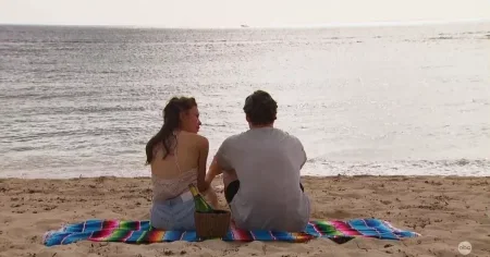 Johnny and Gabby sit on the beach