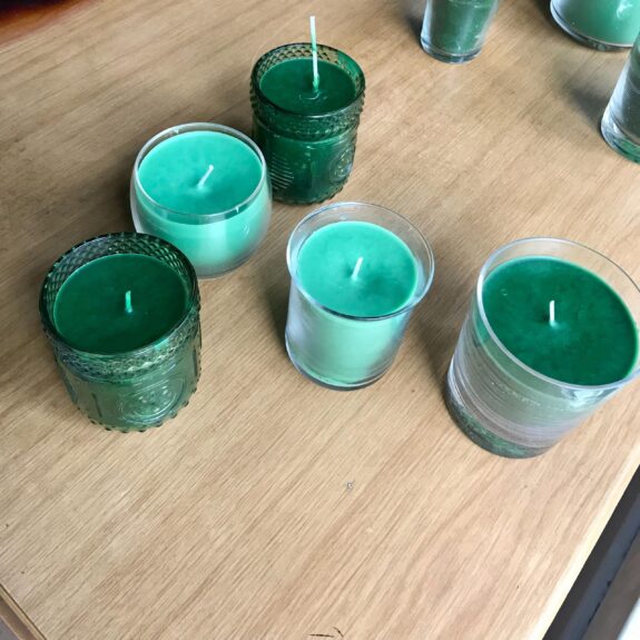 mint green and forest green candles on a wooden table