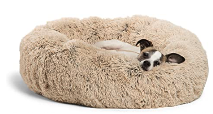 A very fluffy shaggy pet bed with a tiny dog snoozing in it happily