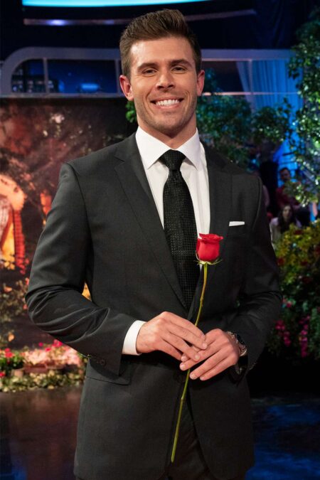 Zach smiles and holds a rose