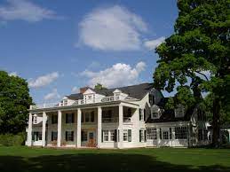 Photo of Hill Stead, a white house with pillars surrounding a porch
