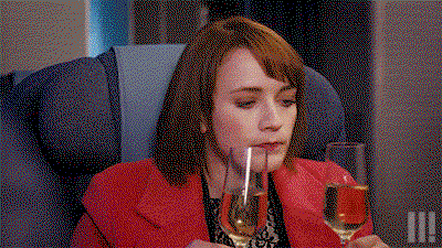 a woman drinks from 2 glasses of wine at the same time