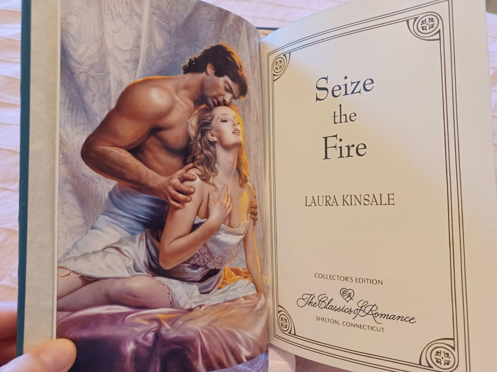 Seize the Fire title page with title author Laura Kinsale and the Romance Classics script logo and a stepback showing a very muscular white man behind a blonde white woman and they're probably supposed to be conveying ecstasy but it makes them look like they have gas cramps
