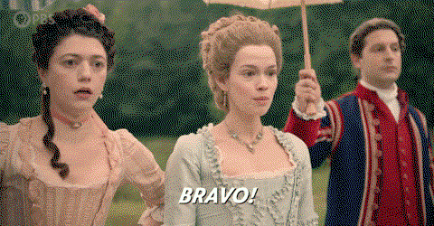 A woman in period dress says bravo and claps