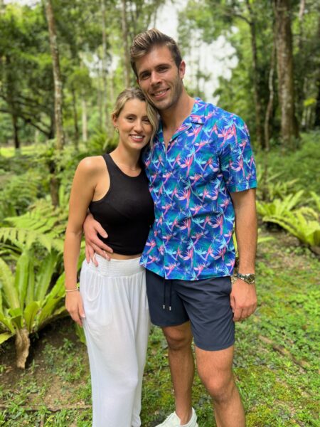 Zach, wearing an ugly blue patterned shirt with pink something-with-tentacles on it shirt, stands next to Kaity.
