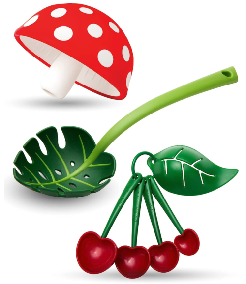 A set of three gadgets - a kitchen funnel shaped like a red mushroom with white spots, a slotted spoon ladle shaped like a leaf, and a set of measuring spoons designed to look like a bunch of cherries with a leaf on top 