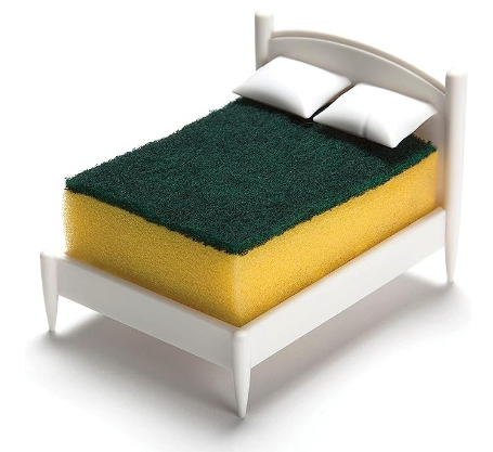 A white plastic molded sponge holder designed to look like a bed with little pillows to hold the sponge in place and an open base so it will drain and dry 