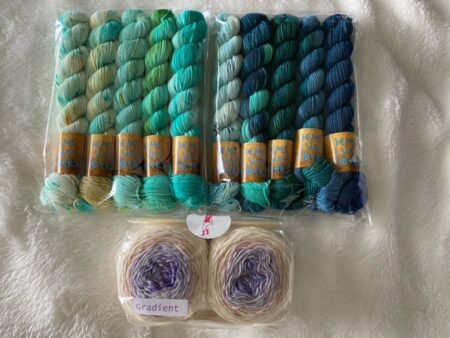 Two mini skein sets in tropical colors and two gradient sock cakes that go from lavender to cream.
