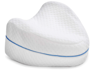 contour knee pillow that is shaped like a rounded arrowhead and has divots in the top and bottom for one's legs 
