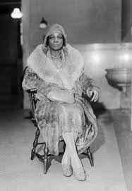 Madame St. clair resplendent in a turban and fur coat